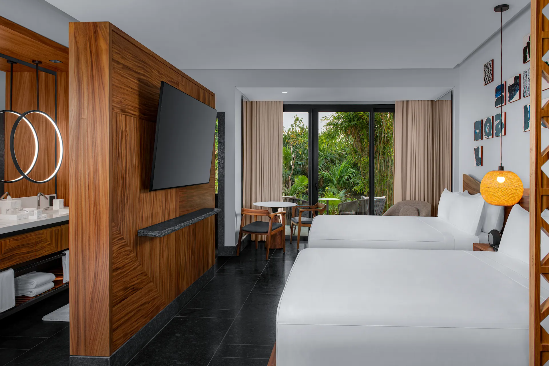 Tropical View Guestroom with 2 Queen Beds featuring modern decor, double sinks, and lush garden views.