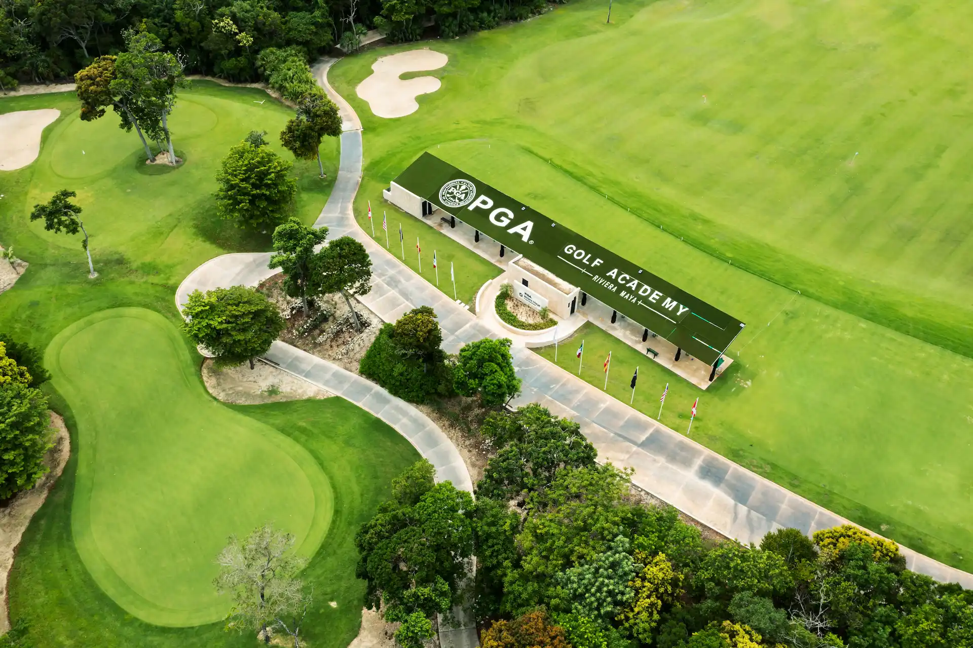 Aerial view of PGA Golf Academy Riviera Maya surrounded by lush fairways, sand bunkers, and tropical greenery.