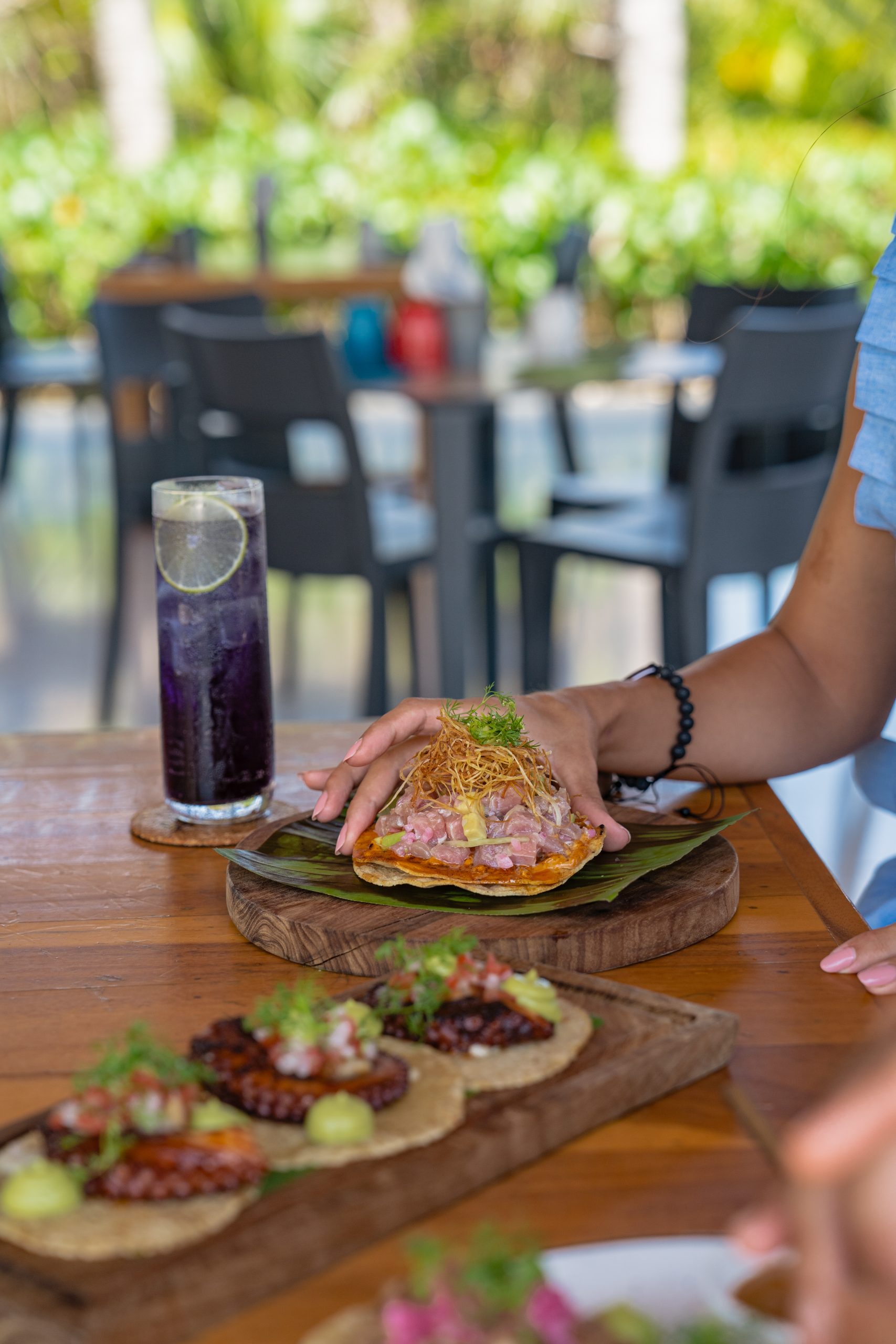 Server presenting traditional Tulum cuisine at the hotel restaurant with elegant tropical ambiance.